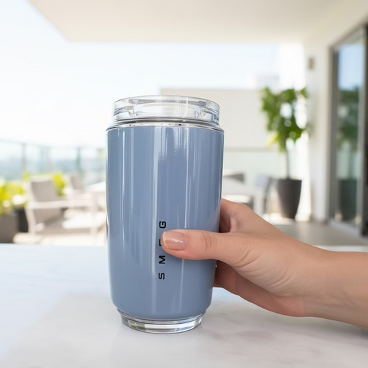 Blue tumbler with 'Smeg' branding on a kitchen counter