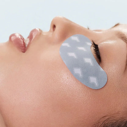 Woman with a gray patch on her face against a light blue background