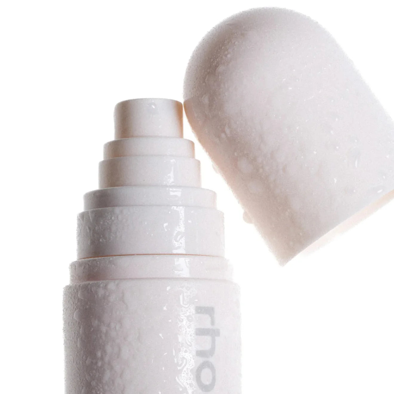 White cosmetic bottle with cap on a white background